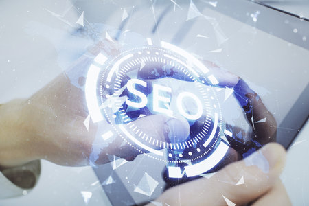Multi exposure of man's hands holding and using a digital device and seo drawing. search optimization concept.の写真素材