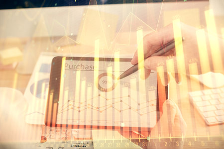 Double exposure of man's hands holding and using a phone and financial chart drawing. Market analysis concept.の写真素材