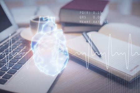 Double exposure of heart drawing and desktop with coffee and items on table background. Concept of medical educationの写真素材