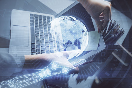 Double exposure of woman hands working on computer and world map hologram drawing. International...