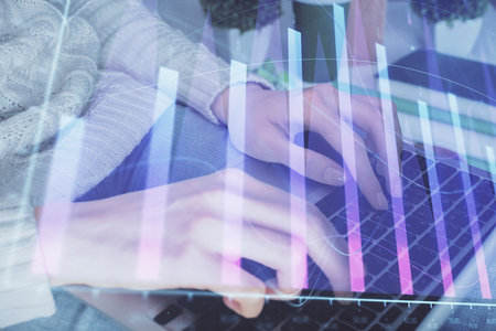 Double exposure of woman hands typing on computer and forex chart hologram drawing. Stock market invest concept.の写真素材