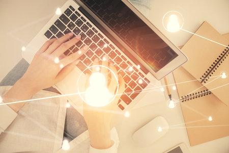 Double exposure of woman hands working on computer and social network theme hologram drawing. Top View. People connection concept.の写真素材