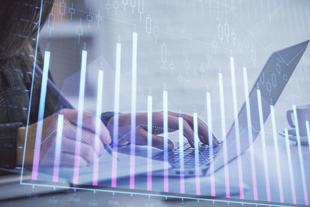 Double exposure of businesswoman hands typing on computer and forex graph hologram drawing. Financial analysis concept.の写真素材