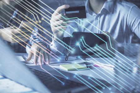 Double exposure of man and woman on-line shopping holding a credit card and data theme hologram...