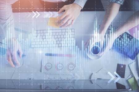 Double exposure of man and woman working together and financial chart hologram drawing. market analysis concept. Computer background. Top View.の写真素材