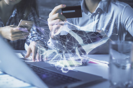 Double exposure of man and woman on-line shopping holding a credit card and handshake hologram drawing. Partnership concept.の写真素材