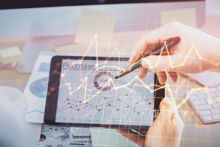 Double exposure of man's hands holding and using a phone and financial chart drawing. Market analysis concept.の写真素材