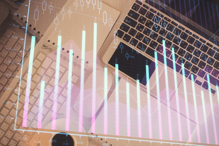 Financial market graph and top view computer on the desktop background. Multi exposure. Investment concept.の写真素材