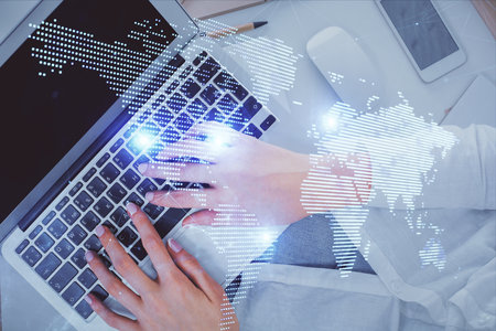 Double exposure of woman hands working on computer and social network theme hologram drawing. Top View. People connection concept.の写真素材