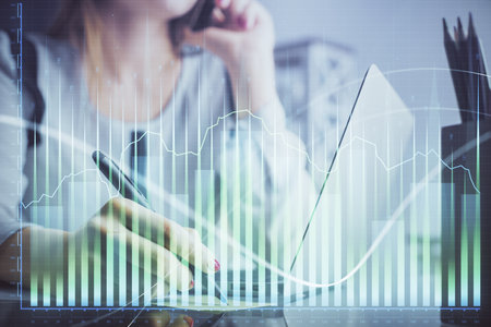 Double exposure of woman hands typing on computer and financial graph hologram drawing. Stock market analysis concept.の写真素材