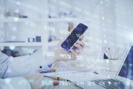 Double exposure of man's hands holding and using a digital device and forex graph drawing. Financial market concept.の写真素材