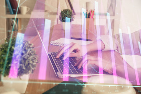 Double exposure of woman hands typing on computer and forex chart hologram drawing. Stock market invest concept.の写真素材