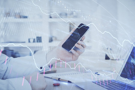 Double exposure of man's hands holding and using a digital device and forex graph drawing. Financial market concept.の写真素材
