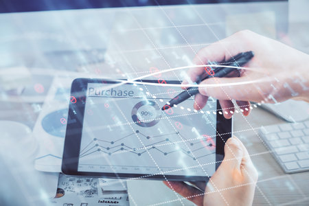 Double exposure of man's hands holding and using a phone and financial chart drawing. Market...