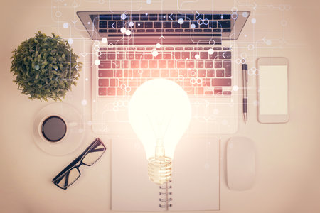 Bulb drawing over computer on the desktop background. Top view. Double exposure. Idea concept.の写真素材