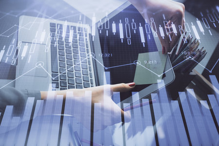 Double exposure of businesswoman hands typing on computer and financial graph hologram drawing. Stock market analysis concept.の写真素材