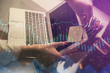 Double exposure of businesswoman hands typing on computer and financial graph hologram drawing. Stock market analysis concept.の写真素材