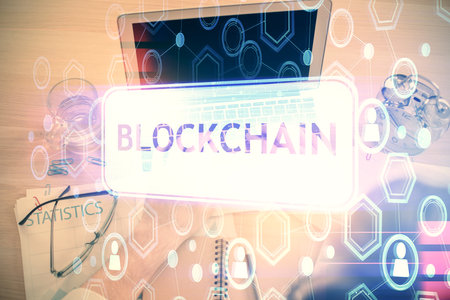 Double exposure of man's hands typing over computer keyboard and crypto currency theme hologram drawing. Top view. Blockchain concept.の写真素材