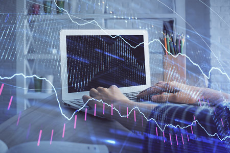 Double exposure of woman hands typing on computer and forex chart hologram drawing. Stock market invest concept.の写真素材