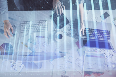 Multi exposure of man and woman working together and financial chart hologram. Business concept. Computer background.の写真素材