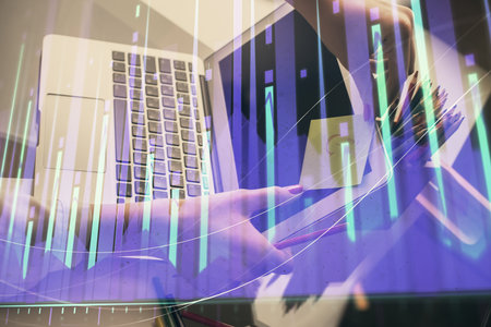 Double exposure of businesswoman hands typing on computer and financial graph hologram drawing. Stock market analysis concept.の写真素材