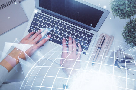 Double exposure of woman hands working on computer and world map hologram drawing. Top View. International business concept.の写真素材
