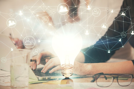 Double exposure of woman hands typing on computer and light bulb drawing. Idea concept.の写真素材