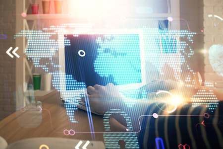 Double exposure of woman hands working on computer and world map hologram drawing. International technology business concept.の写真素材