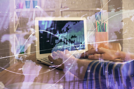 Double exposure of woman hands typing on computer and forex chart hologram drawing. Stock market invest concept.の写真素材