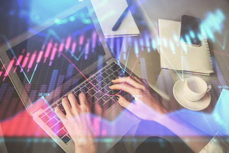 Double exposure of woman hands typing on computer and forex chart hologram drawing. Stock market invest concept.の写真素材