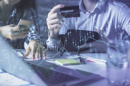 Double exposure of man and woman on-line shopping holding a credit card and forex graph hologram drawing. Stock market E-commerce pay on-line concept.の写真素材
