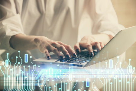 Double exposure of woman hands working on computer and data theme hologram drawing. Tech concept.の写真素材