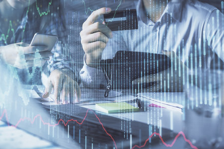 Double exposure of man and woman on-line shopping holding a credit card and forex graph hologram drawing. Stock market E-commerce pay on-line concept.の写真素材