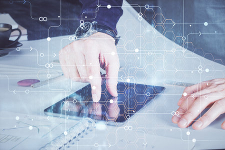 Double exposure of man's hand holding and using a digital device and data theme drawing. Technology concept.の写真素材