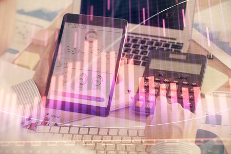 Double exposure of man's hands holding and using a digital device and forex graph drawing. Financial market concept.の写真素材