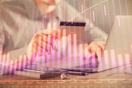 Double exposure of man hands holding a credit card and Forex graph drawing. Stock trading and digital fintech in Internet E-commerce concept.の写真素材