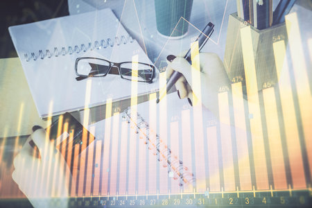 Multi exposure of woman on-line shopping holding a credit card and financial graph drawing. Stock market E-commerce concept.の写真素材