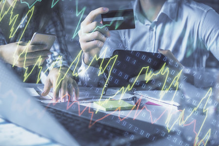 Double exposure of man and woman on-line shopping holding a credit card and forex graph hologram...