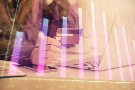 Multi exposure of woman on-line shopping holding a credit card and financial graph drawing. Stock market E-commerce concept.の写真素材