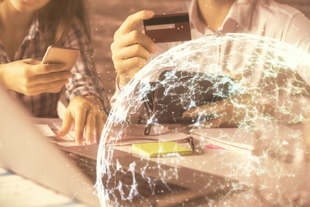 Double exposure of man and woman on-line shopping holding a credit card and social network theme hologram drawing. People connecting and E-commerce pay on-line concept.の写真素材