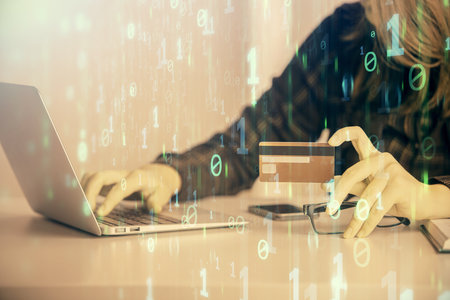 Double exposure of woman on-line shopping holding a credit card and data theme hologram drawing. E-commerce concept.の写真素材