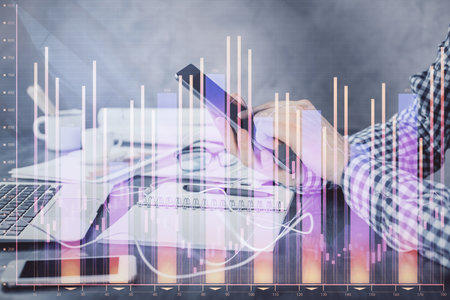 Double exposure of man's hands holding and using a digital device and forex graph drawing. Financial market concept.の写真素材