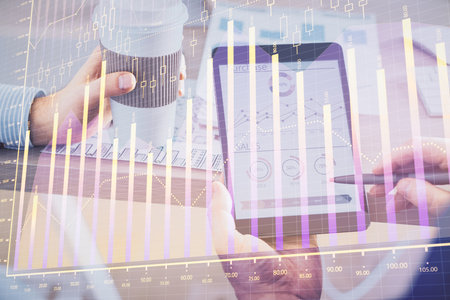 Double exposure of man's hands holding and using a phone and financial chart drawing. Market analysis concept.の写真素材