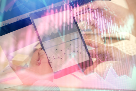 Double exposure of man's hands holding and using a phone and financial chart drawing. Market analysis concept.の写真素材