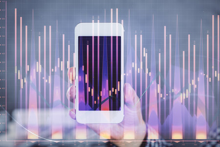 Double exposure of man's hands holding and using a digital device and forex graph drawing. Financial market concept.の写真素材