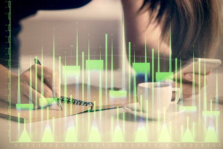 Double exposure of forex graph sketch hologram and woman holding and using a mobile device. Stock market concept.の写真素材
