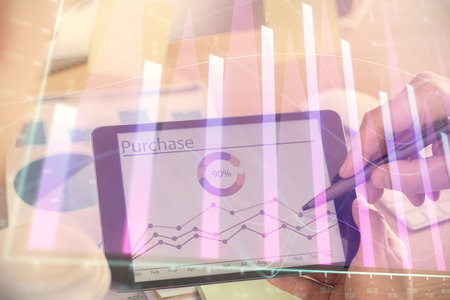 Double exposure of man's hands holding and using a phone and financial chart drawing. Market analysis concept.の写真素材