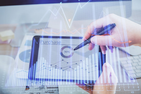 Double exposure of man's hands holding and using a phone and financial chart drawing. Market analysis concept.の写真素材