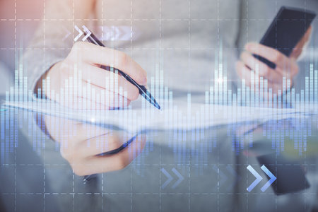 Double exposure of forex chart sketch hologram and woman holding and using a mobile device. Financial market concept.の写真素材