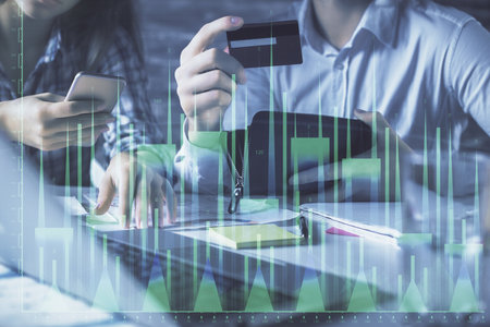 Double exposure of man and woman on-line shopping holding a credit card and forex graph hologram drawing. Stock market E-commerce pay on-line concept.の写真素材